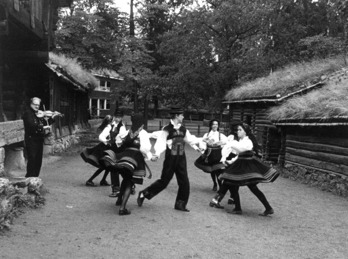 Norsk folkemuseums ungdomsleikarring opptrer, i anledning av Norsk folkemuseums barne- og ungdomsleikarings 25 års jubileumsforestilling, september 1978. Setesdalstunet.