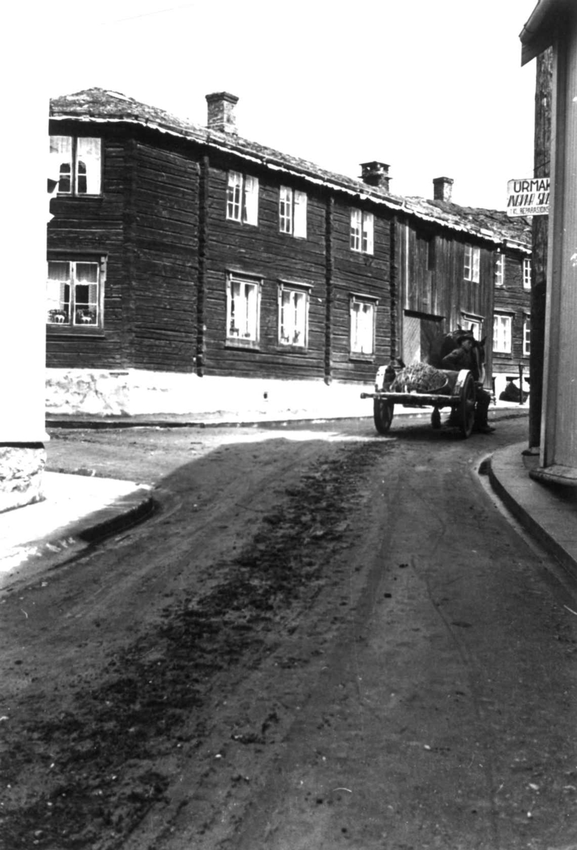 Gatebilde med bygninger og en mann med kjerre, 7. juni 1939.