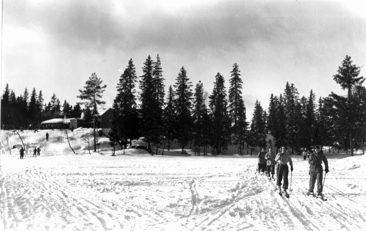 Skiløpere i Nordmarka, Oslo. 1934. Tryvannstua ses i bakgrunnen.