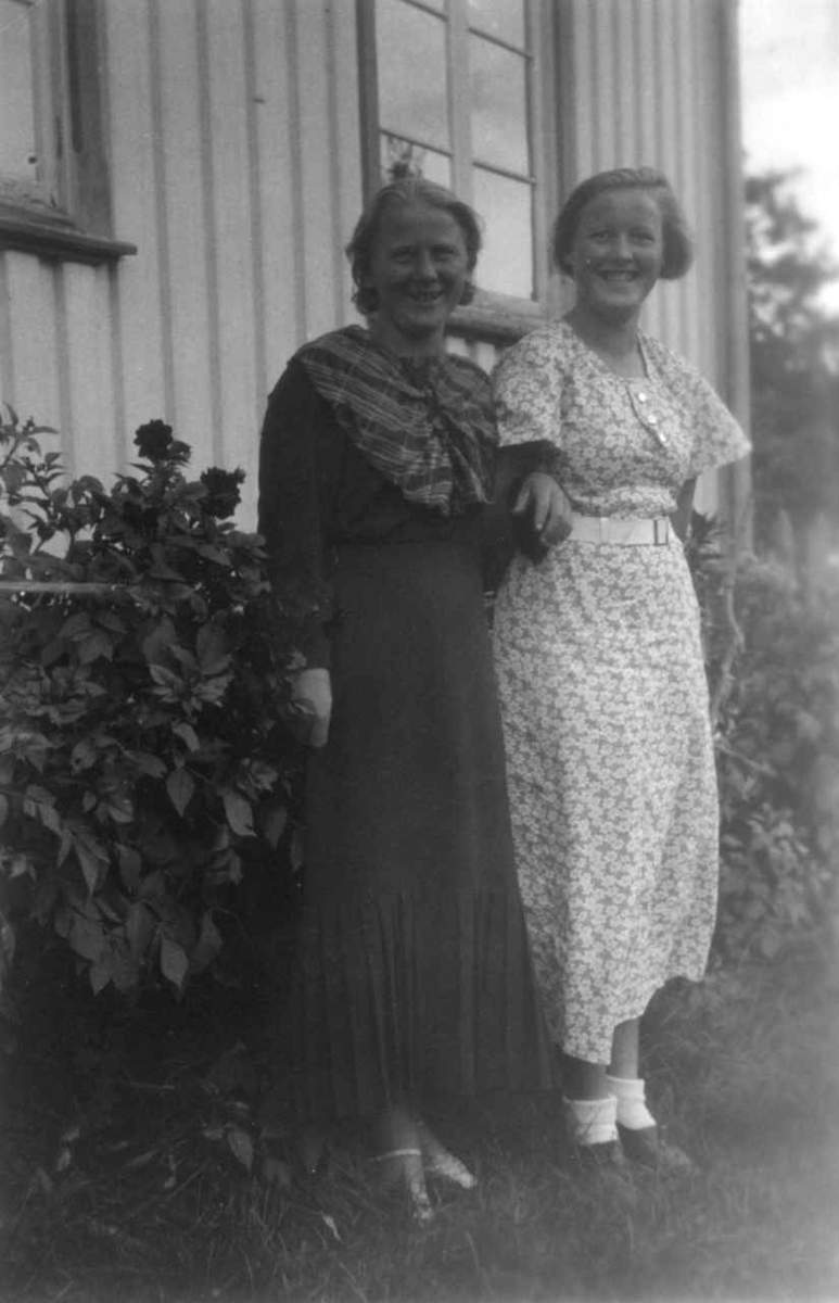 Tjenestejenta på Austenå og Liv Austenå poserer foran en husvegg.  Tovdal 1936.