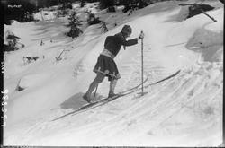 Kvinnelig skiløper i skidrakt med skjørt.