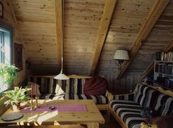 Sofagruppe i loftstue under skråtak i bolig ved Normannsvik 