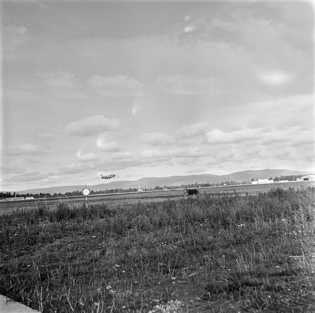 Serie. Mange uniformskledde personer er samlet i anledningen at et jagerfly skal bryte lydmuren. Jagerpiloten sitter i flyet. Fotografert 12. og 13. september 1955.