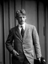 Portretter, fiolinist Due. Står ved en stol.