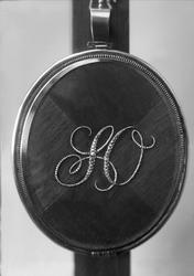 Henriksens monogram på baksiden av medaljong.