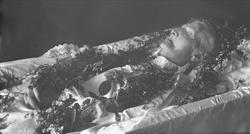 Post mortem-fotografi. Død kvinne i kiste.