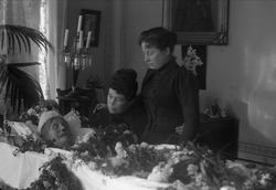 Post mortem-fotografi. Kvinne i pyntet kiste, siste farvel f