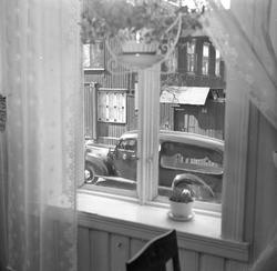 Begravelsesbyrå. Bilde tatt gjennom et kjøkkenvindu. 1956.