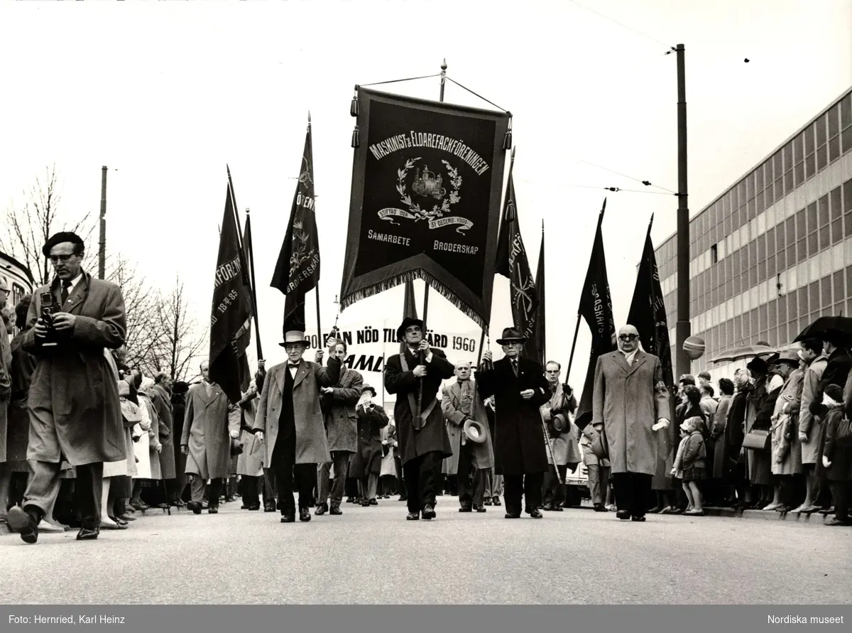 Demonstration 1:a maj. Fana med texten "MASKINIST & ELDAREFACKFÖRENINGEN STIFTAD DEN 31 DECEMB. 1900. SAMARBETE BRODERSKAP