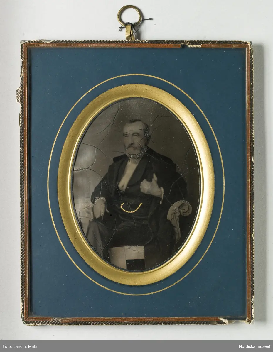 Porträtt av äldre man. Föreställer urboettmakaren Anders Wilhelm Åberg född 9/4 1803, död 3/11 1866, Stockholm. Förgylld klockkedja. Panotyp i ram.
Nordiska museet inv.nr 211091.