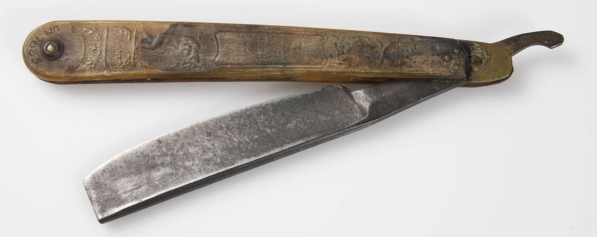 Rakkniv med skaft av nästan genomskinligt horn med pressad dekor i relief, bland annat duva, puttin, krona, skepp samt text "PLENTI" och "PEACE". Blad av stål märkt: P. FORD.