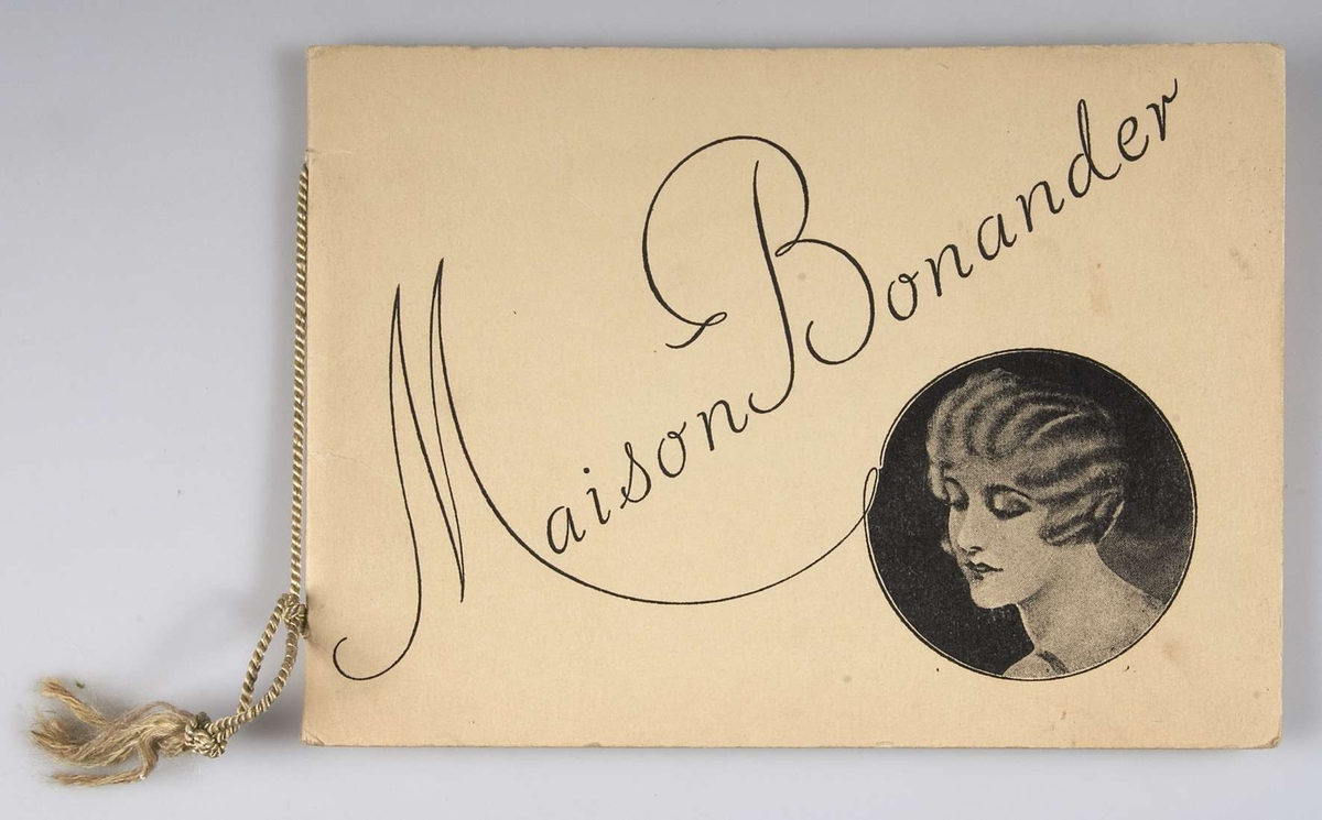 Reklamkatalog med ljusgul pärm och bunden i ryggen med gult snöre. Tryckt text på framsidan: Maison Bonander. Tryckt 1928. Innehåller reklam för ondulering, skönhetsvård, hårvård och manicure. "Maison Bonander GÖTEBORG".