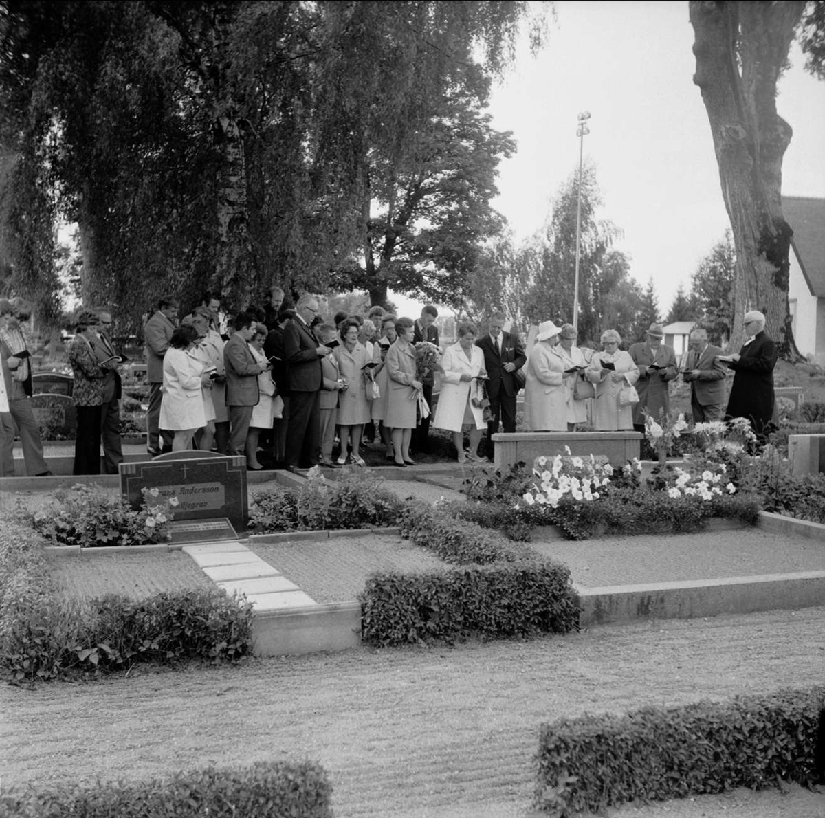 Släkt- och kusinträff på Tierps kyrkas kyrkogård, Uppland september 1972. Grupp samlad framför grav