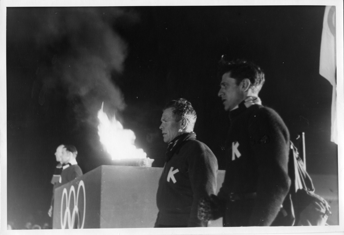 Arnholdt Kongsgård (t.v.) og Petter Hugsted under fakkelseremoni på Kirketorget på Kongsberg i forbindelse med OL 1952. Arnholdt Kongsgård and Peter Hugsted during the tourch ceremony in Kongsberg 1952.