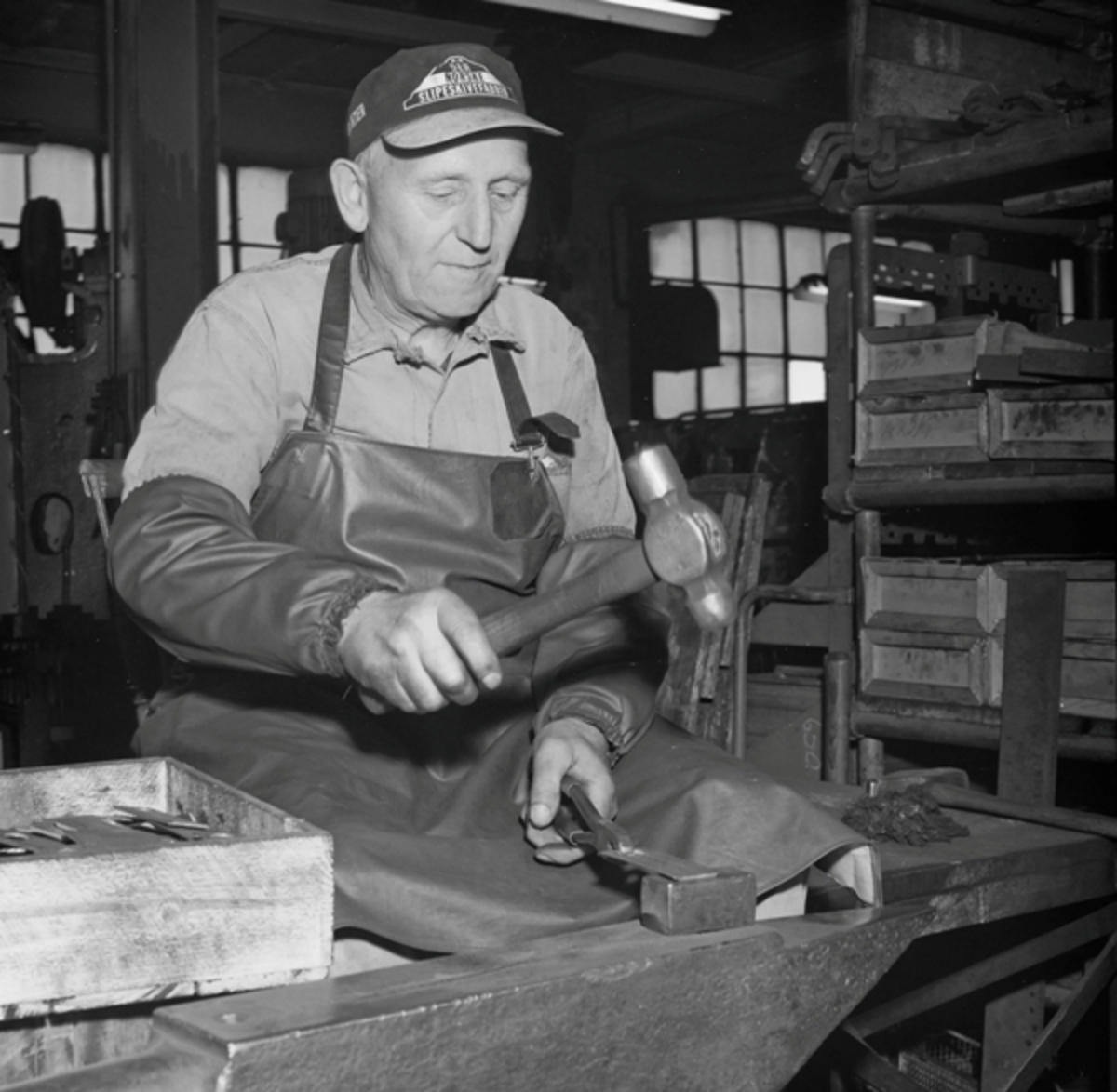 Olav Mæland arbeider med hammer i verkstedet til Kvernelands Fabrikk AS på Kvernaland