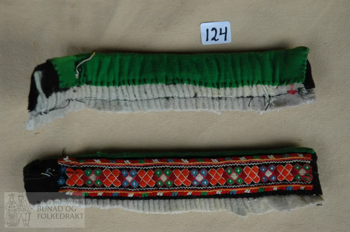 Fremre del av linning("line"). Svart klede med løyesaum, kanta øverst med grøn ull-lerret. Har høyrt saman med ein understakk.