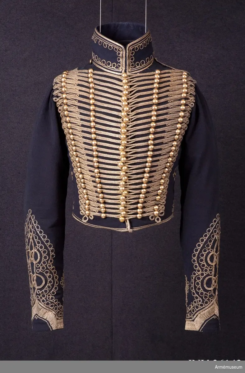 Grupp C I.
Dolma av mörkblått officerskläde med snörmakerier av guldtråd.