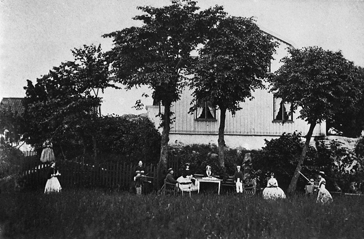 Enligt tidigare noteringar: "Personer i trädgården framför gavel på manbyggnaden, Gräskärr."