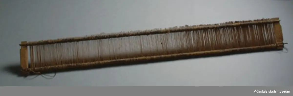 Vävsked med skedbredd 740 mm. Märkt med ett bomärke på ena kortsidan och ett annat på den andra kortsidan. Tillverkad runt mitten av artonhundratalet. "Vävsked", även ritt eller vävkam, vävredskap bestående av en rad lameller ("tänder") i ett ramverk. Mellan lamellerna träs varptrådarna, varefter vävskeden sätts in i en slagbom. Källa: Nationalencyklopedin.