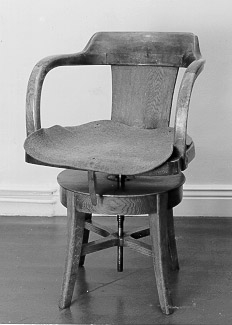 Stol med ryggstöd och halvcirkelformat ramstycke. Stolen
ärhöj- och sänkbar genom en metallskruv.
