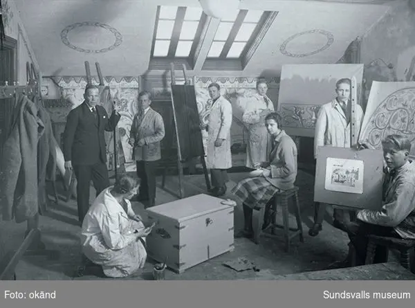 Gustaf Walles (stående i kostym till vänster) lärare för dekorationsmåleri vid Sundsvalls yrkes- och lärlingskola, tillsammans med sina elever. Walles var lärare på skolan från 1929 till 1965.