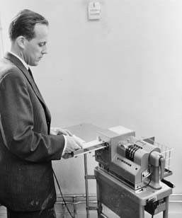 Frankeringsmaskin för paketadresskort. I bruk i kassaexpeditionen,
avdelningen för massinlämning av paket. Foto 6/11 1958.