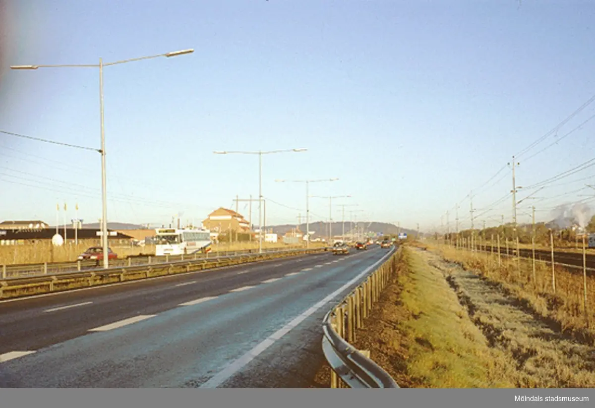 Till vänster ses Astra Hässle (röd, hög byggnad) i Åbro industriområde. Till höger ses järnvägsspår (Östersundsbanan samt för pendeltåg), oktober 1993.