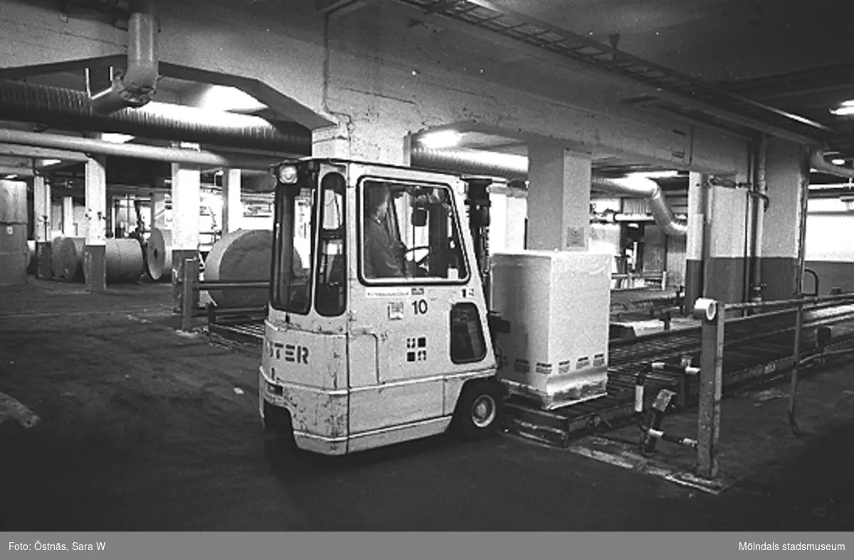 En man kör truck med en pappersbal, 1980-tal.
Bilden ingår i serie från produktion och interiör på pappersindustrin Papyrus.