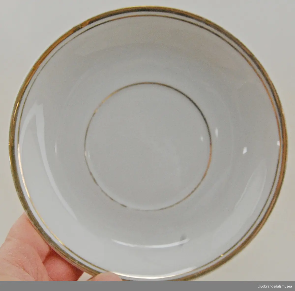 Ni og to hvite skåler med gullstripe rundt langs kanten og i midten hvor koppen skal stå. Har tilhørende kopper. 