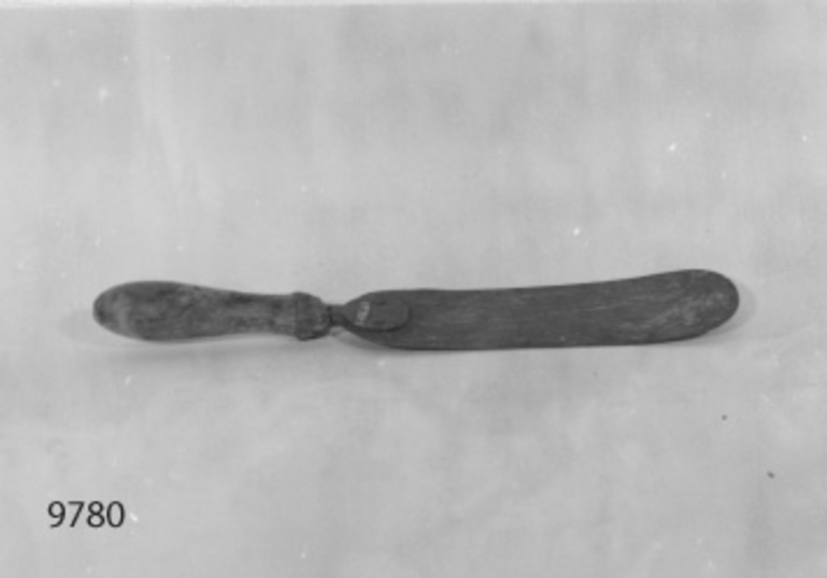 Spade, stek-, av stål med träskaft. Har använts i skeppsgossekårens kokhus under 1800- och in på 1900-talet. Bladet jämnbrett med avrundad spets. Märkt med kronstämpel.