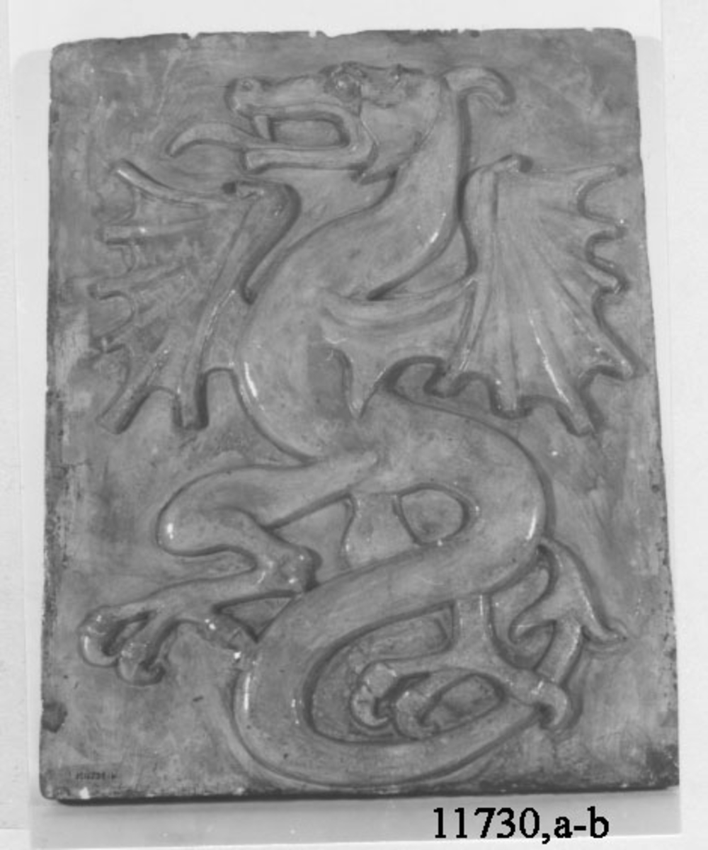 Reliefen visar en drake, färdig till anfall.
Emblem för babordssidan.