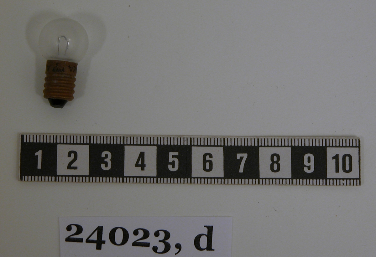 Lampa av typ Luma 4 V A av sidenmattat klarglas. Kronmärkt. Lampan är inte märkt med accessionsnummer.