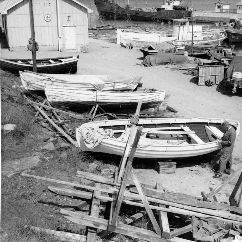 Skåne, Torekov, hamnplanen väster om inre hamnen. I bakgrunden livräddningsbåtens hus, en paragrafbåt och en gammal passagerarslup "MAX". I Förgrunden 3 skånesnipor och en båt av obestämbar typ. Juni 1962
