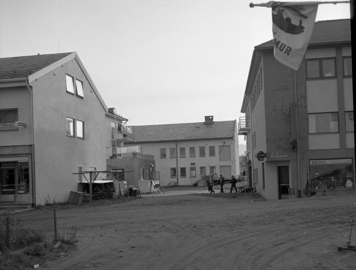 Rådhusgata i Sortland 1966 med Harald M. Jacobsens forretningsgård til venstre og inngangen til Sigurd Skjegstads fotoforretning til høyre.