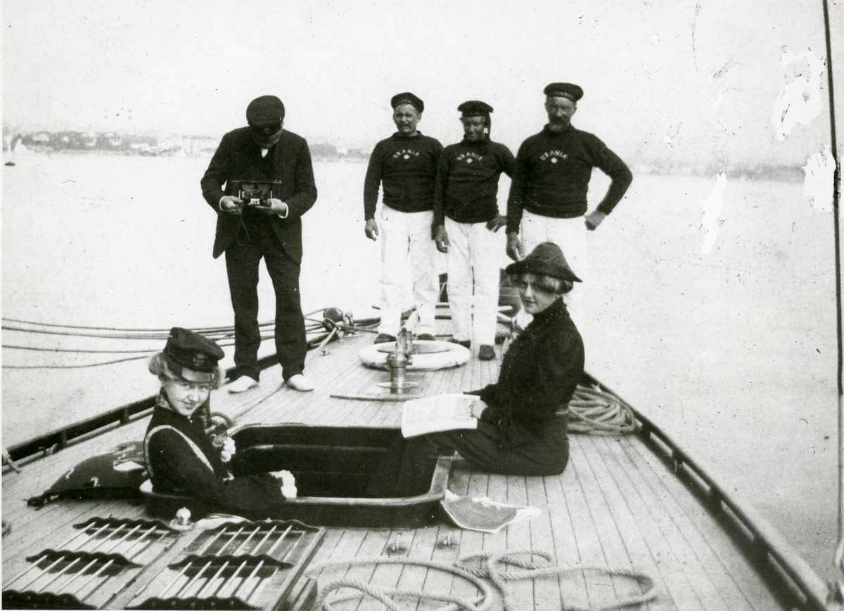 To kvinner og fire menn ombord i seilbåten 'Urania' (b.1895)
