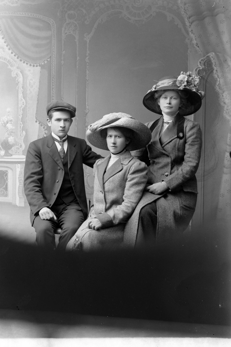 Gruppeportrett av tre personer, fotografert i 1911.