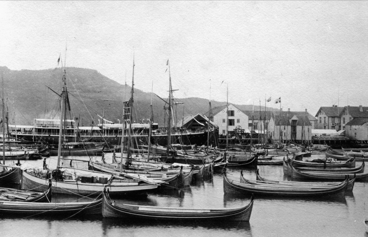 Nordlandsbåter og andre mindre fartøyer samlet ved dampskipskaia i Harstad, før regattaen i 1891. I bakgrunnen et dampskip.