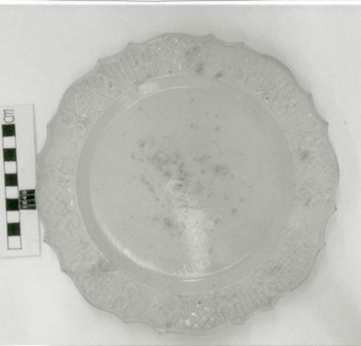 Reliefdekor på brättet, f. ö. slät, grå- beige ton på glasyren. Omärkt.
 
Se Hannover, E: Keramisk handbok I s. 522, fig. 650.