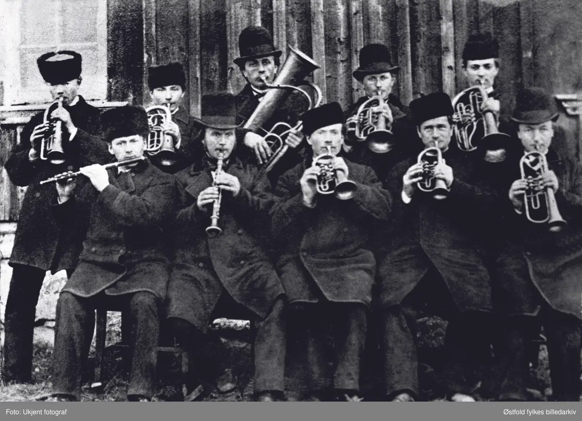 Rakkestad Hornmusikk i 1877. 
Sittende fra venstre: G. A. Jahren, Gudmund Kraugerud, H. Håby, H. Haug og Edvard Westby. 
Stående fra venstre: Johannes Thorstensen Stensrud f. 1858, J. O. Wartvedt, O. J. Heier, Anton Heier og Johan P. Harlem.