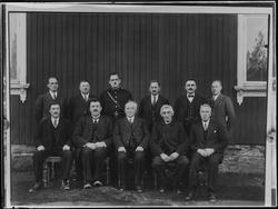 Gruppe, menn utenfor en bygning. Skiptvet, ukjent år.