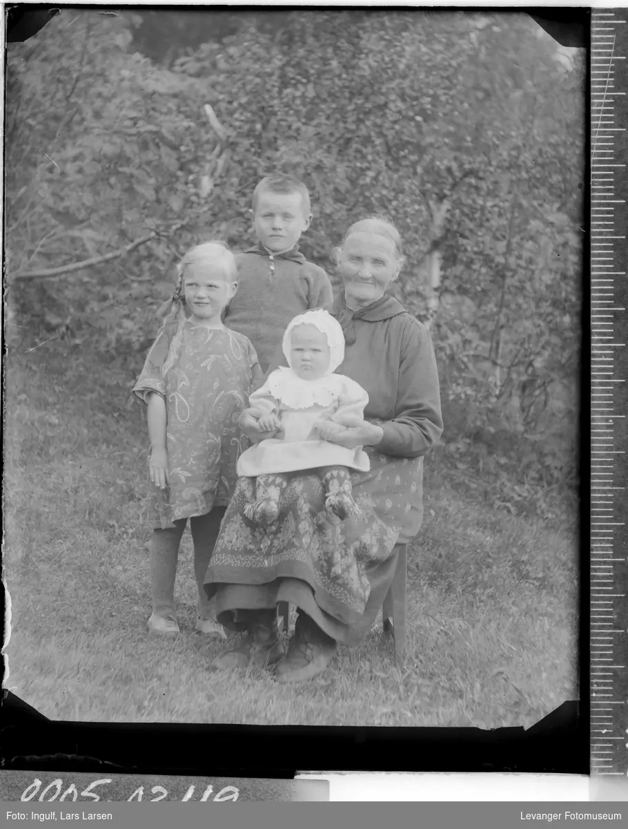Gruppebilde av en eldre kvinne og tre barn.