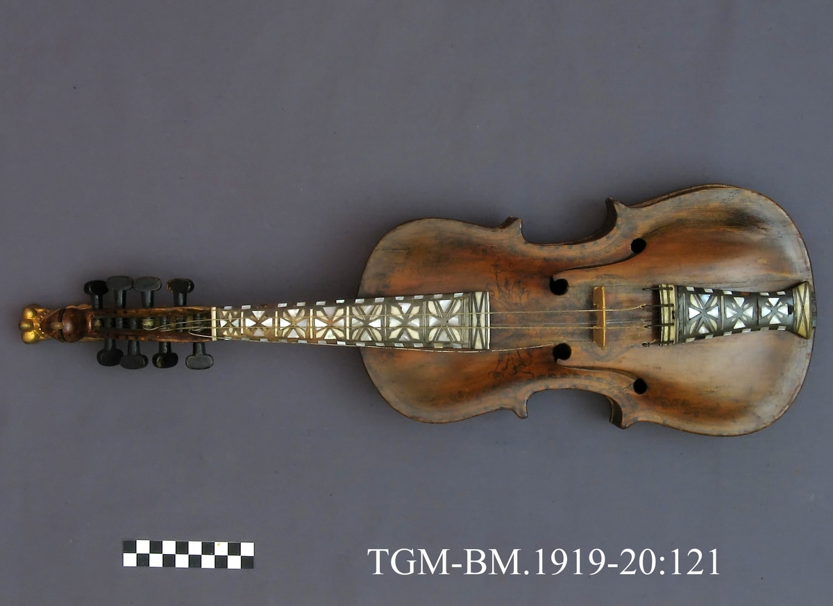 Fra protokollen: Hardingfele av den eldre, smale typen. Bruleggjingi stjerneforma, raud ferniss, stillepinnar og hovud spm vane (Hovudet nygylt). Paa merklappen inni stend: Fabrikeret af Erik Johnsen Helland i Bøe 1838. (Aarstalet ber merke av aa vera retta, serleg seinste siffer; papiret under aarstalet er vekkskrapa og talet uppnya paa berre treet.). Lok av gran, trojsk av hegg, botn av svartor, hovud av bjørk.