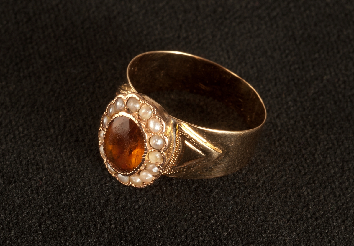 Fingerring av guld, med pärlor och sten av topas. Stämplar: JFAB, 18 K, St Erik, A 7=1903.


