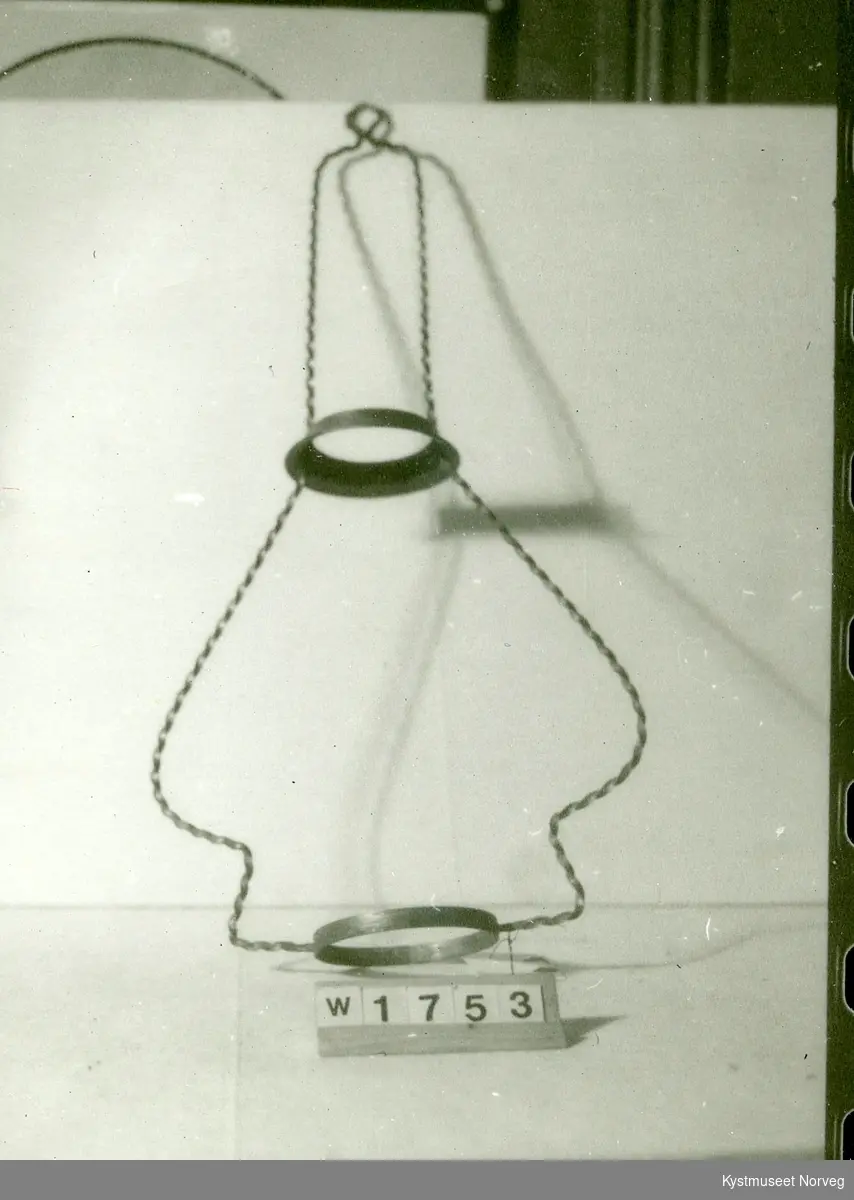 Holderen er laget av et messingbånd med trekantet profil med sider 0,5 cm som er tvunnen. form som på skruer. Ringer til lampe og skjerm.