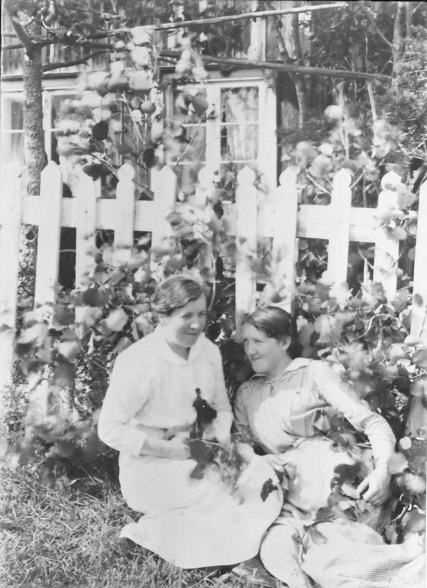 To jenter foran stakittgjerde