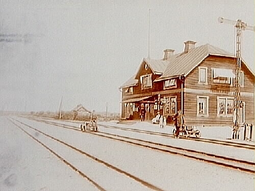 Sköllersta Järnvägsstation, en och en halvvånings stationsbyggnad med brutet tak.Två dresiner med två män.