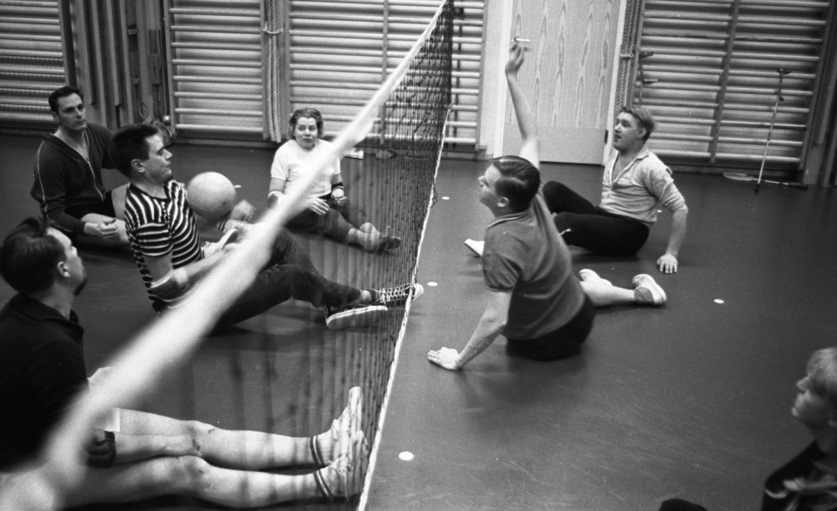 Handikapp basketboll 21 mars 1967

Handikappade sitter på golvet i en gymnastiksal och spelar volleyboll.