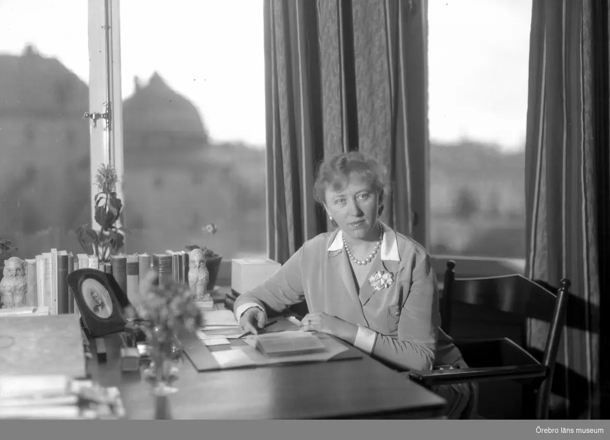 Rumsinteriör, en kvinna vid skrivbordet.
Författarinnan Berit Spong.