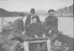 Fire menn i en motorbåt.