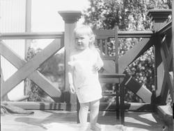 En liten Iacob Ihlen Mathiesen står barbeint på verandaen i 